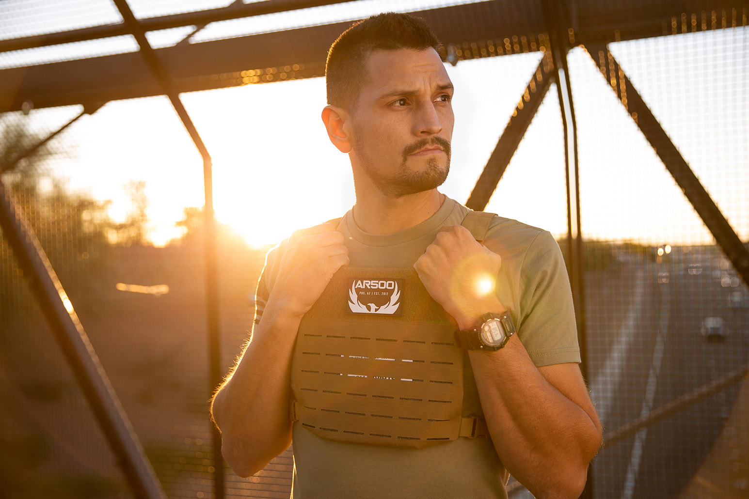 A man wearing the AR Freeman Carrier and holding steel plates from Armored Republic