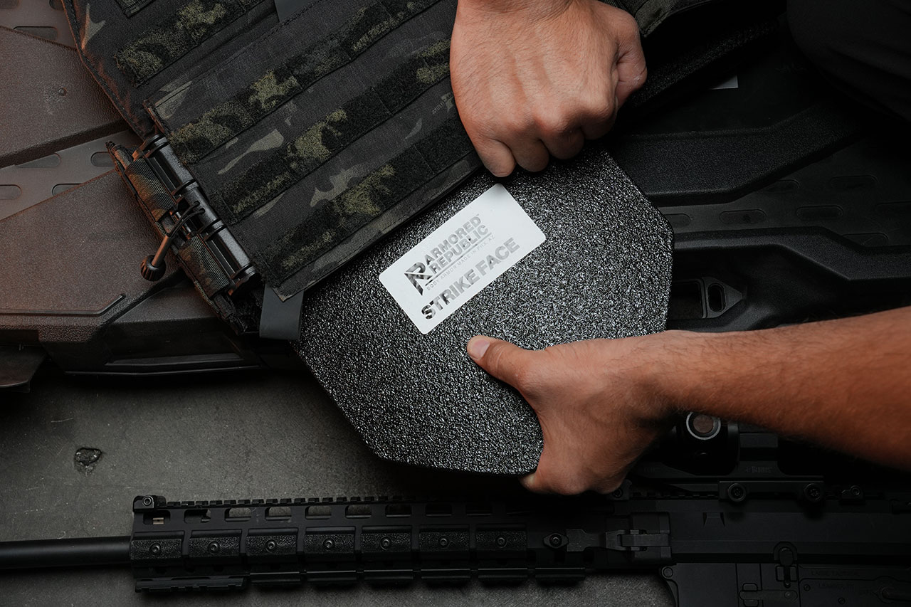 Man inserting armor plate into carrier