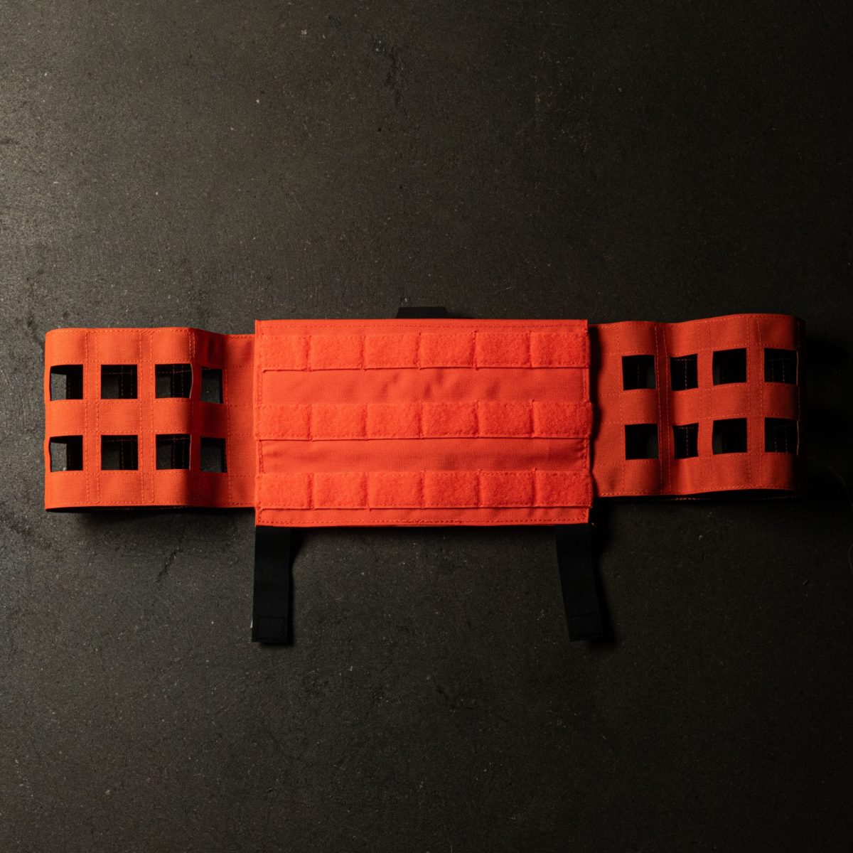 A bright orange MOLLE cummerbund designed for plate carriers, featuring laser-cut MOLLE webbing and Velcro panels for secure attachment and modular customization.