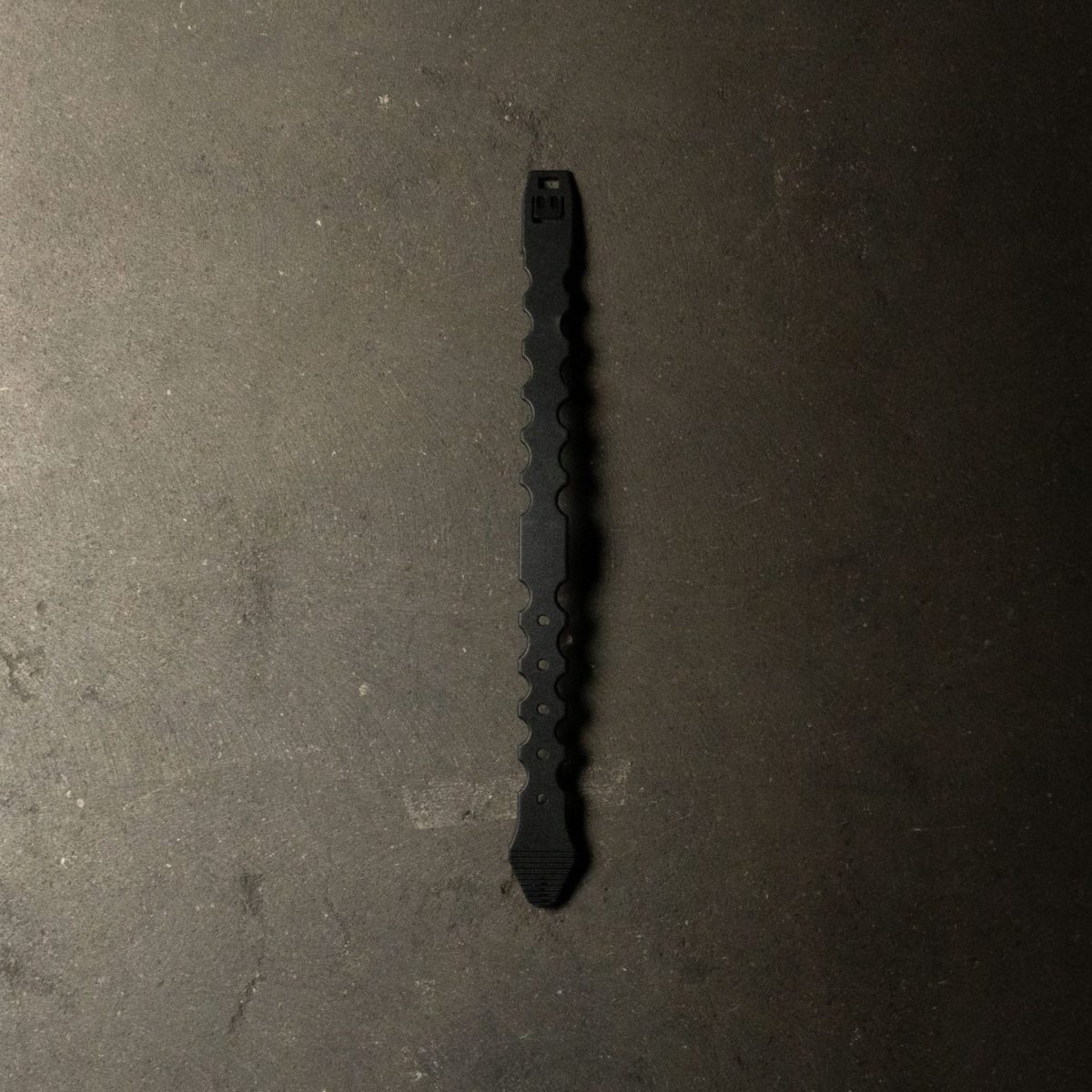 A tan Malice Clip designed for securely attaching MOLLE-compatible pouches and accessories to tactical vests, plate carriers, and backpacks.