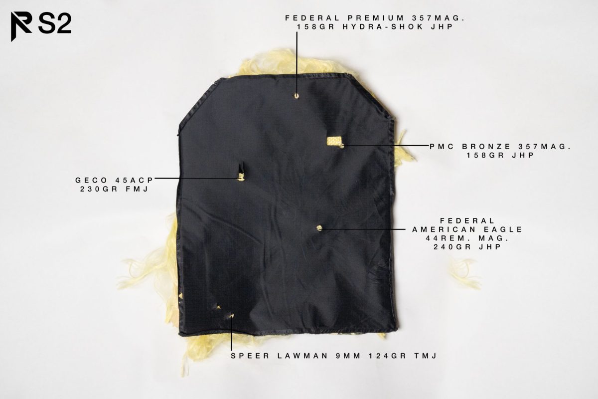 A tested S2 soft armor panel showing bullet impacts from various calibers, including 9mm, .45 ACP, .357 Magnum, and .44 Magnum, with visible penetration results.