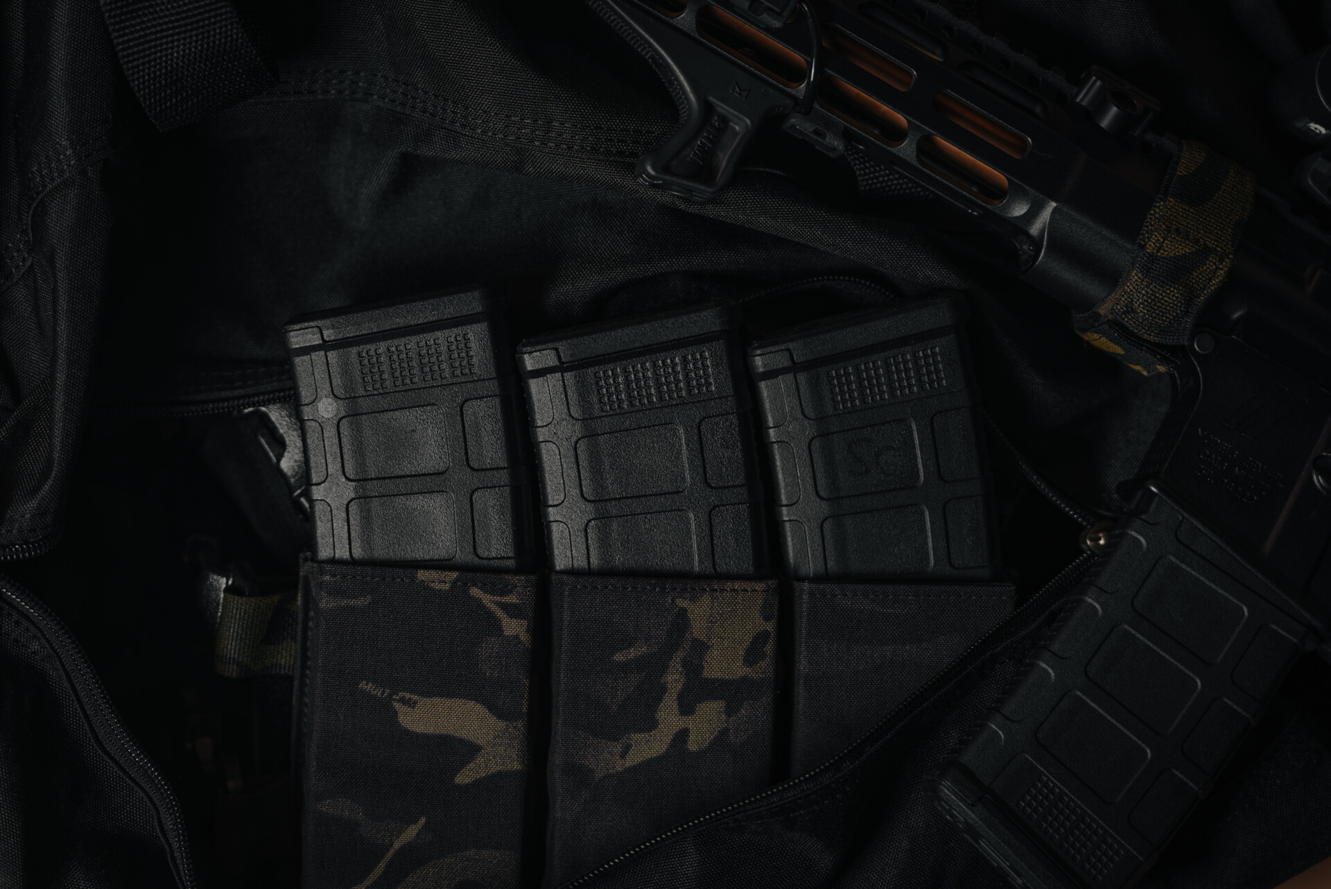 MK1 AR-15 magazines securely placed in a tactical chest rig pouch with a black Multicam design.