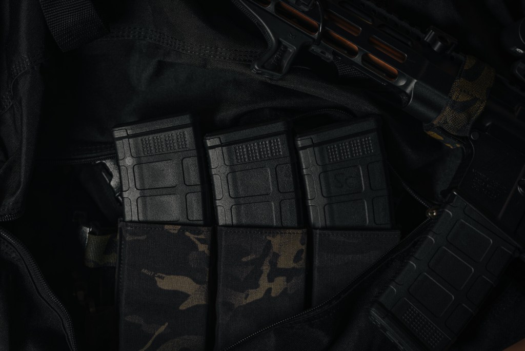 MK1 AR-15 magazines securely placed in a tactical chest rig pouch with a black Multicam design.