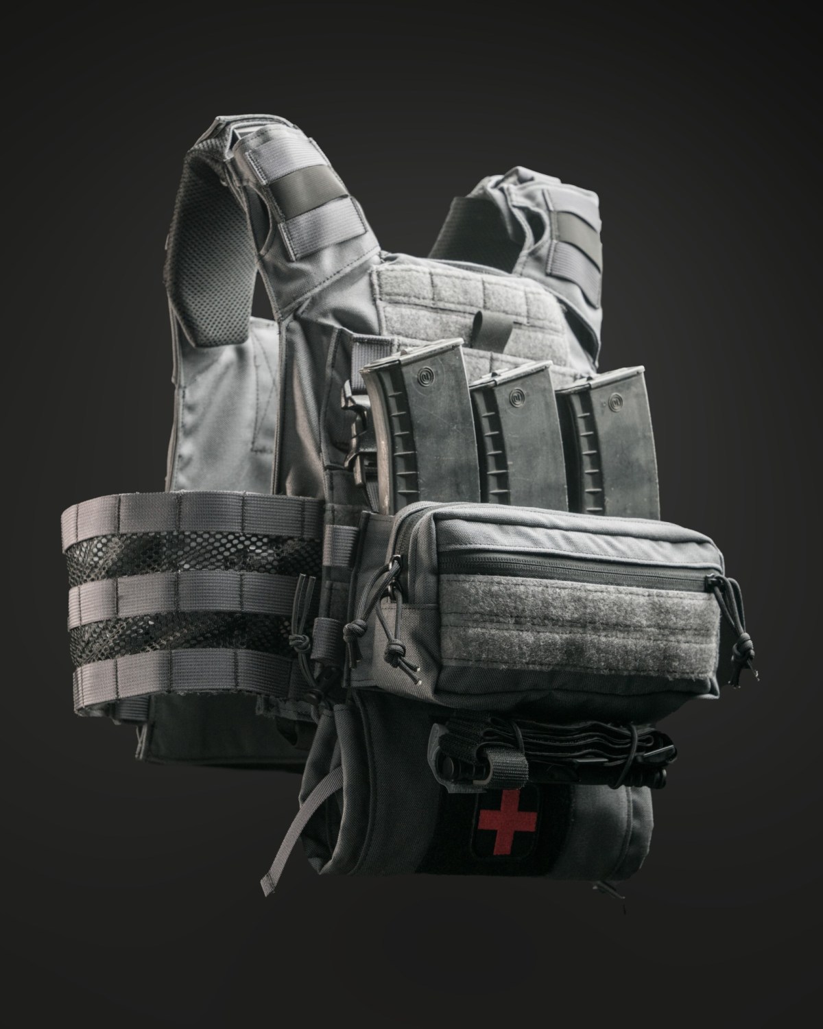 Side view of the Gray Man Kit Valkyrie plate carrier in Wolf Gray, featuring MK I GP Placard, IFAK Med Sleeve Dangler, and breathable skeletonized cummerbund.