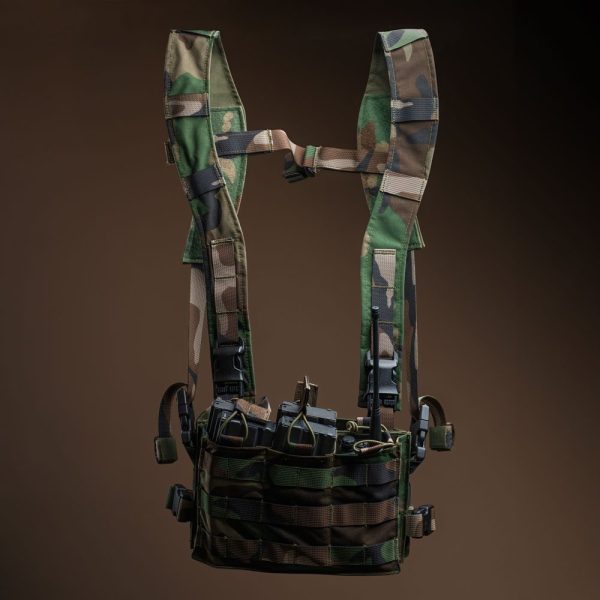A woodland camouflage chest rig equipped with multiple rifle magazine pouches, MOLLE webbing, and adjustable straps for tactical and military use.